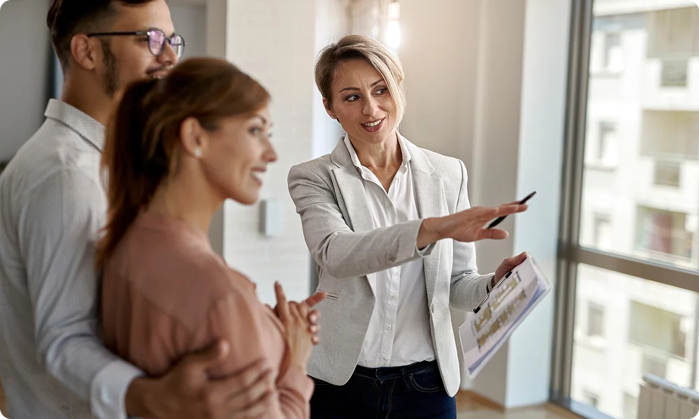 Female real estate agent showing an apartment to a young couple.