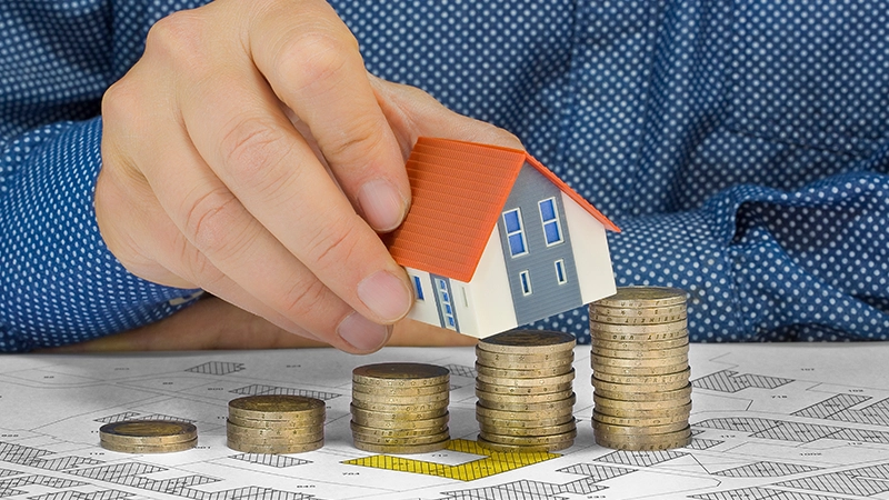 Property Tax on building with coins and a map.